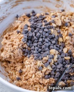 Wholesome Oat Energy Bars 8 mixing chocolate chips in an oat mixture with peanut butter and peanuts.