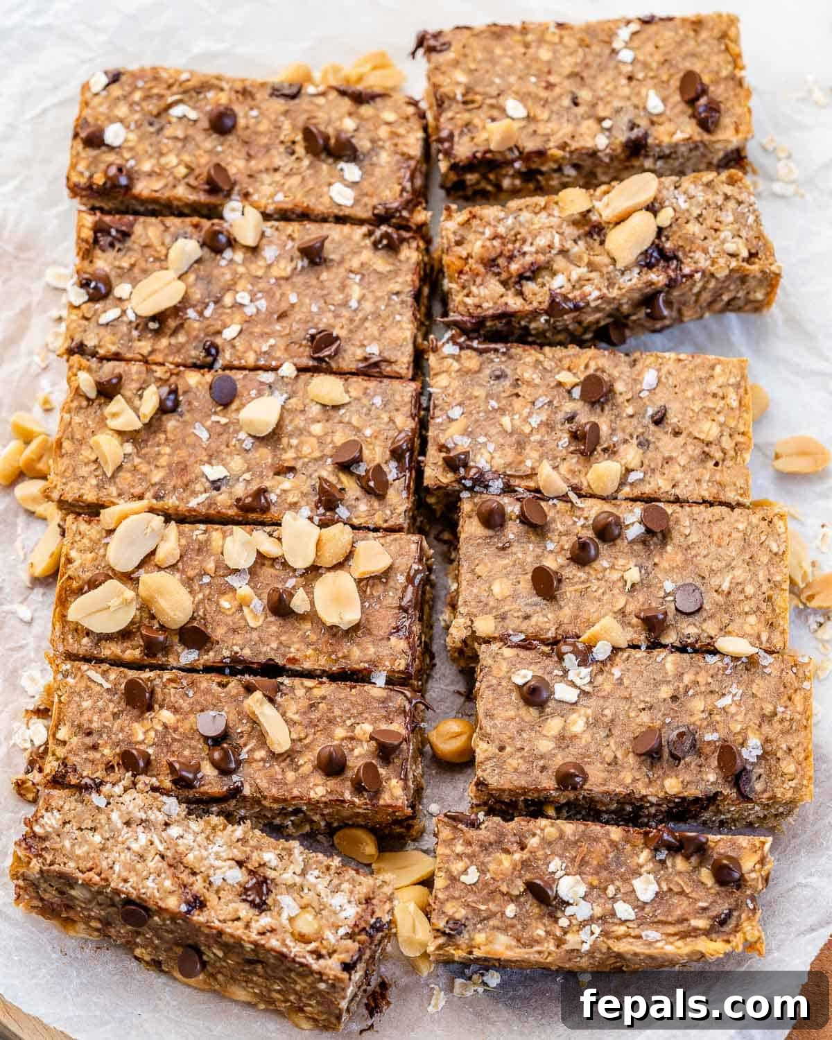 Peanut Butter Chocolate Chip Oatmeal Bars Close-up view of baked oatmeal bars generously studded with chocolate chips and crunchy peanuts, showcasing their soft, chewy texture.