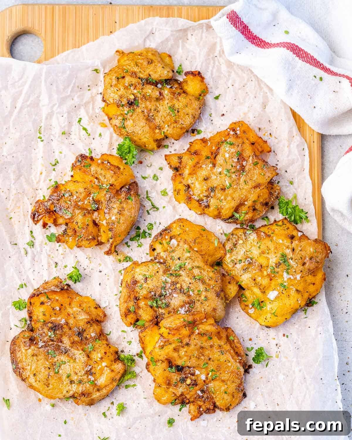 Roasted Smashed Potatoes smashed potatoes on parchment paper with herbs and seasoning