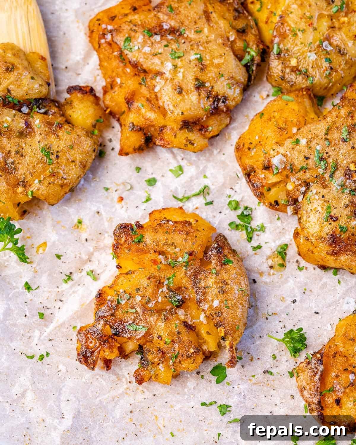 Garlic Smashed Potatoes close view of seasoned smashed potatoes with salt and pepper with parsley