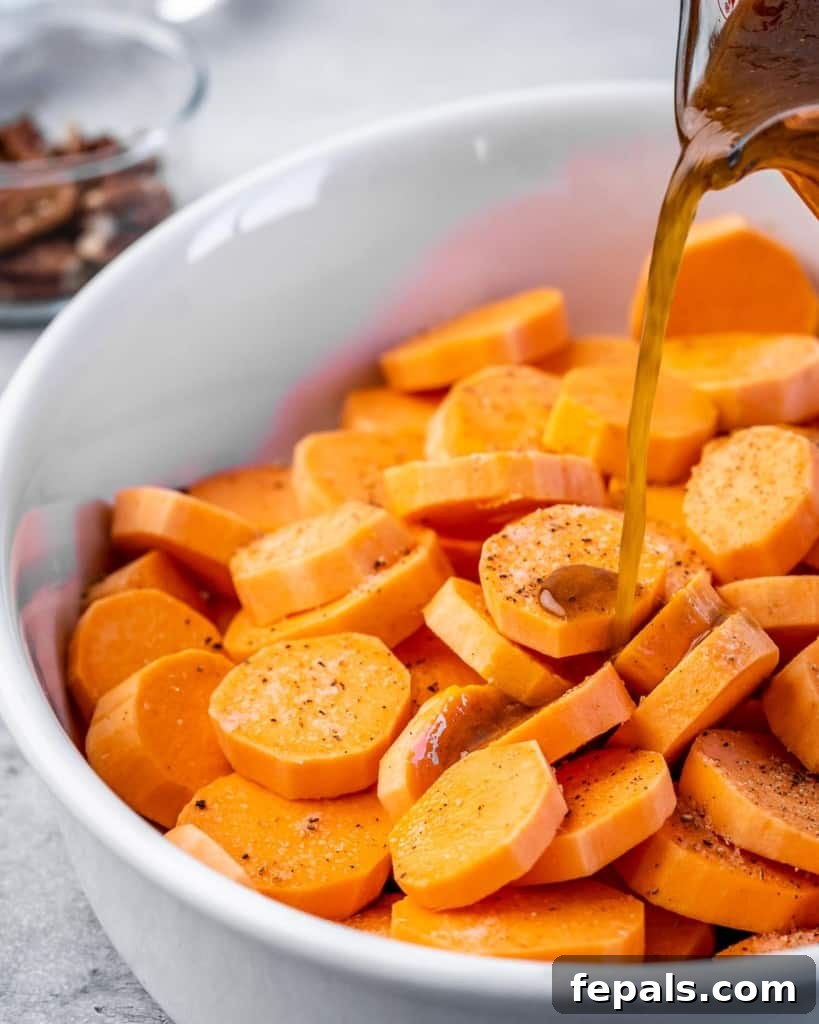 Caramelized Sweet Potato Bake 5 maple syrup mix with spices being poured over sliced sweet potatoes in a white dish before baking