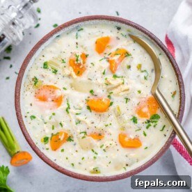 Velvety Chicken and Rice Comfort 11 creamy chicken and rice soup in a bowl with a spoon in the bowl.