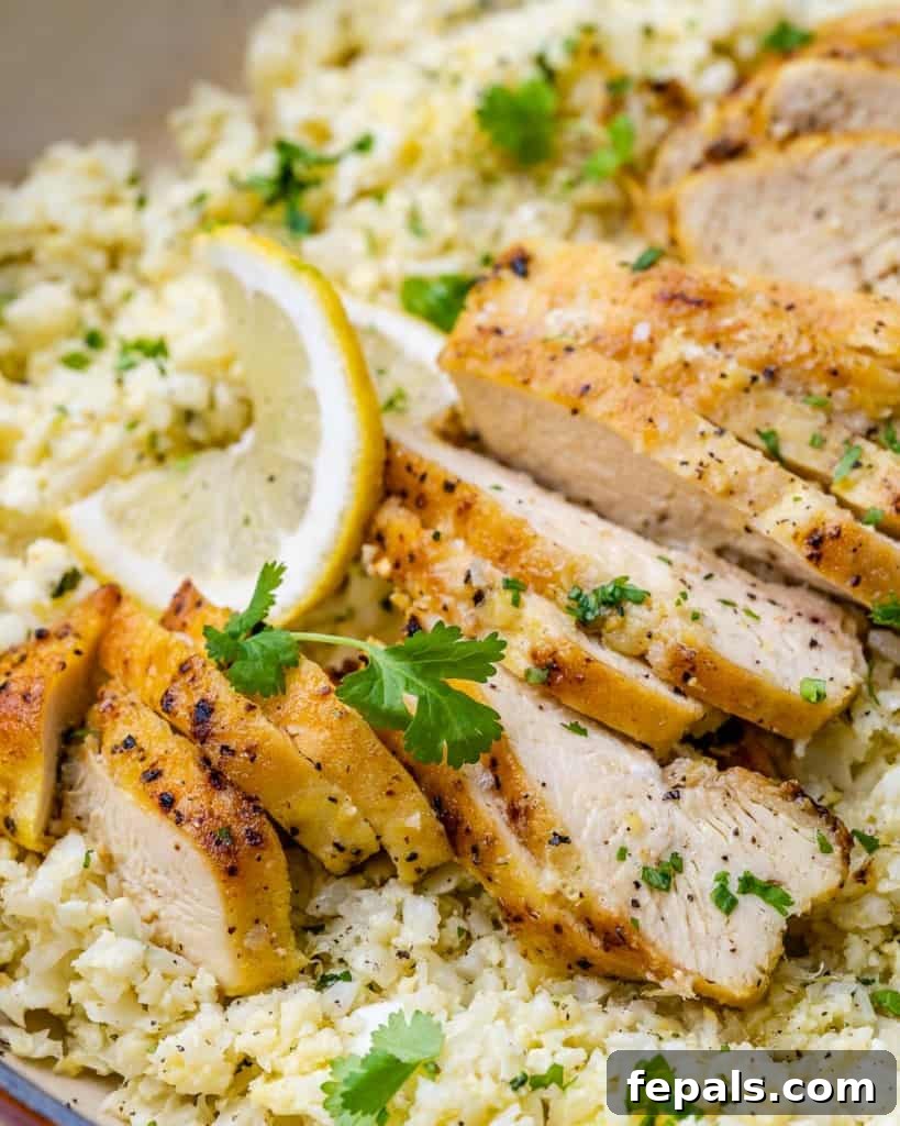 Golden Pan-Seared Lemon Garlic Chicken 3 Close up view of succulent sliced lemon garlic chicken breast over fluffy cauliflower rice, ready to be enjoyed.