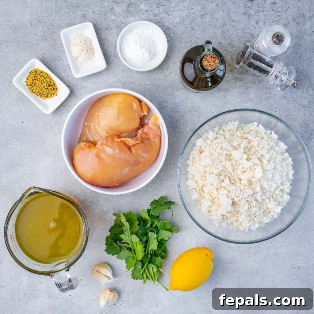 Golden Pan-Seared Lemon Garlic Chicken 4 A collection of fresh ingredients laid out, including chicken breasts, lemons, garlic, cauliflower, and seasonings, ready to make lemon garlic chicken breast over cauliflower rice.