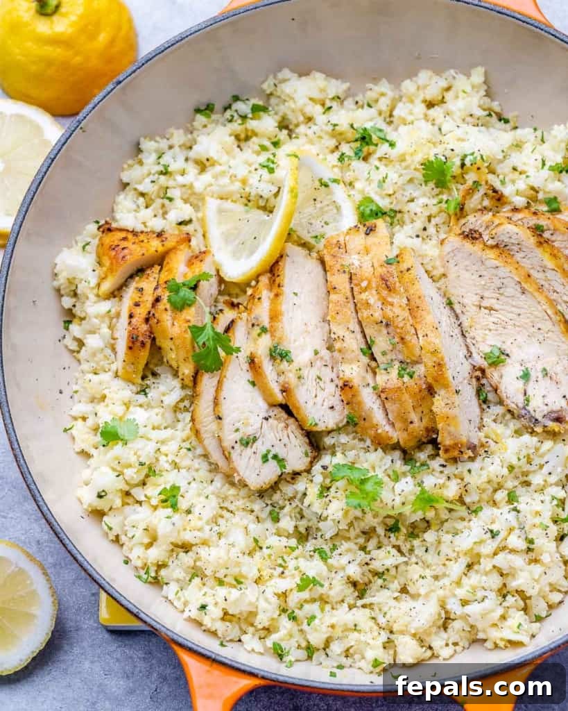 Golden Pan-Seared Lemon Garlic Chicken 8 Another top view of sliced lemon garlic chicken breast served over cauliflower rice in an orange skillet, highlighting its meal prep potential.