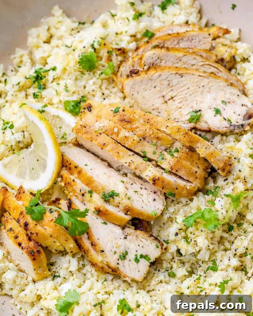 Golden Pan-Seared Lemon Garlic Chicken 10 Close up view of succulent sliced chicken breast over cauliflower rice, inviting you to try this amazing recipe.