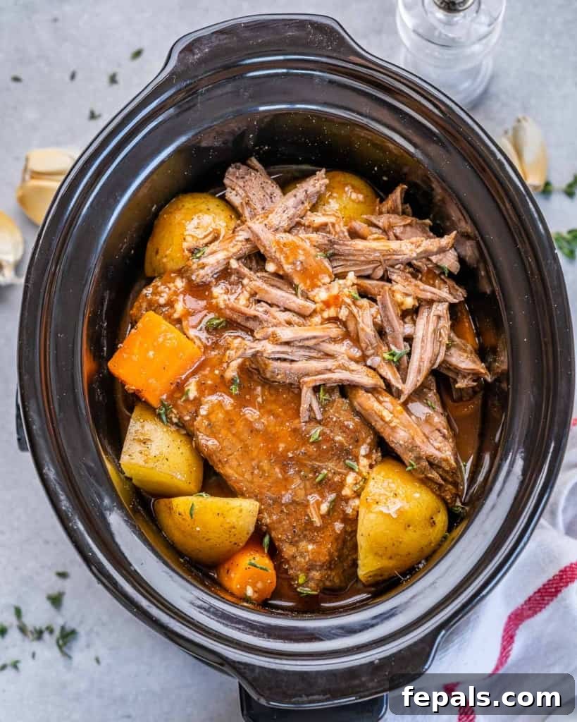 top view pot roast in a slow cooker with potatoes and carrots 