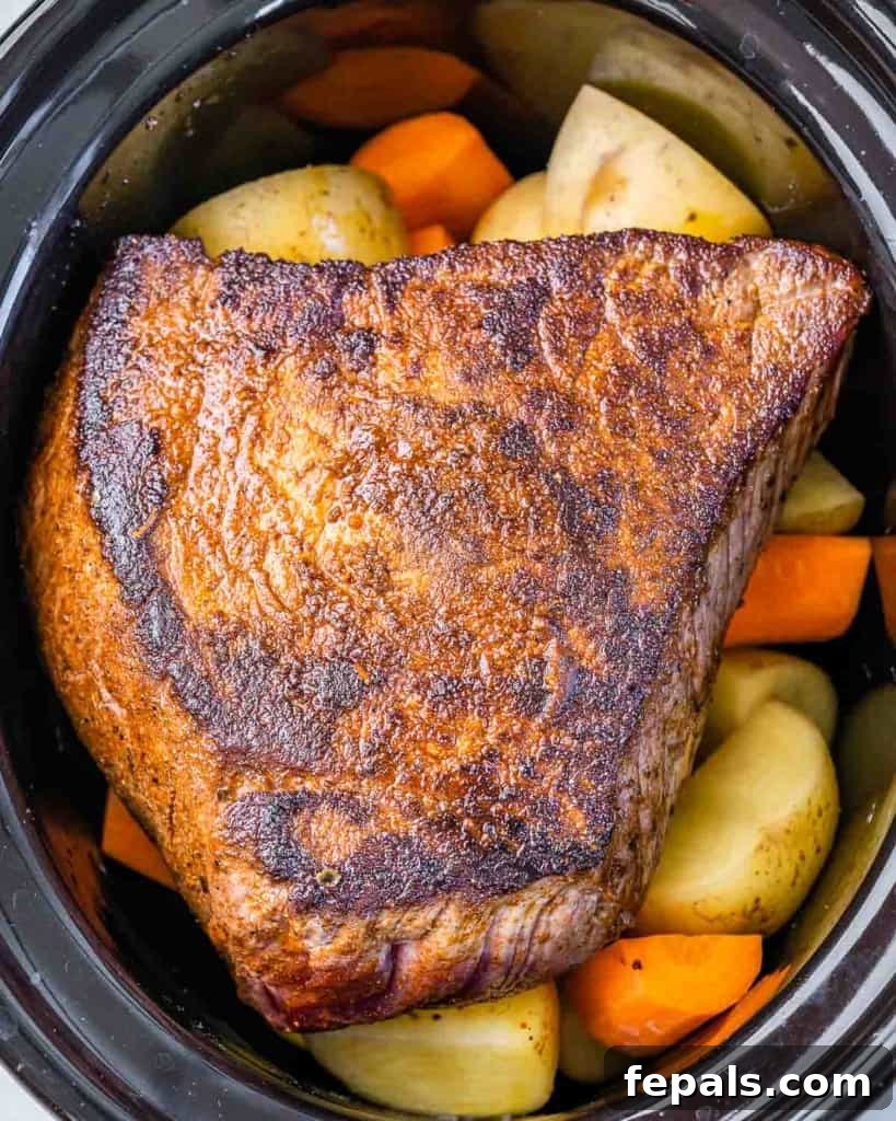 pot roast with veggies in the slow cooker before being cooked 