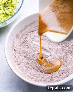 egg and oil liquid mixture being poured over the dry flour mixture