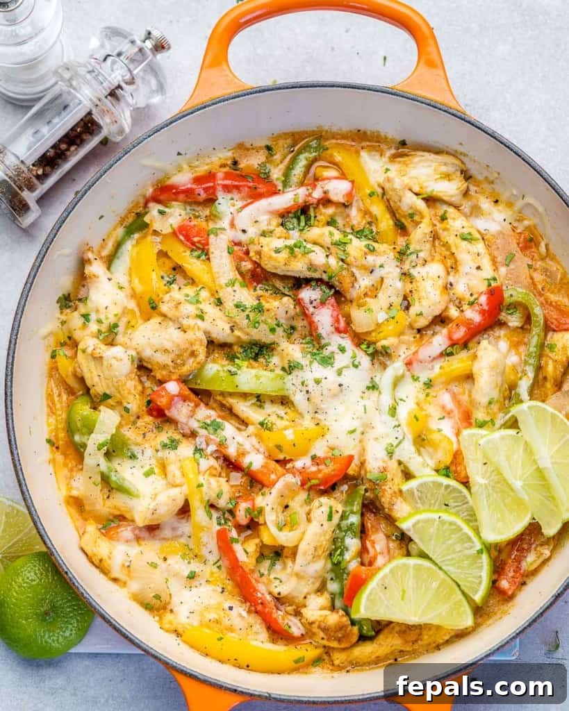 Dreamy Creamy Chicken Fajita Skillet 2 Top-down view of a vibrant creamy chicken fajita skillet with colorful bell peppers and melted cheese, ready to serve.