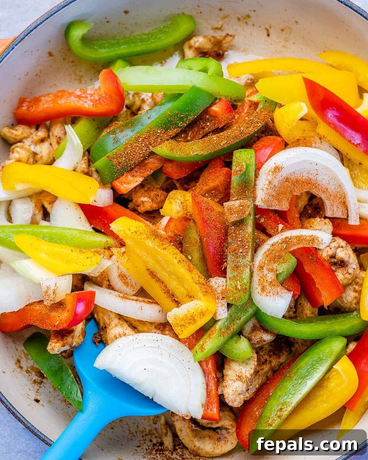 Dreamy Creamy Chicken Fajita Skillet 7 Vibrantly seasoned bell peppers and onions sautéing alongside chicken in a hot skillet.