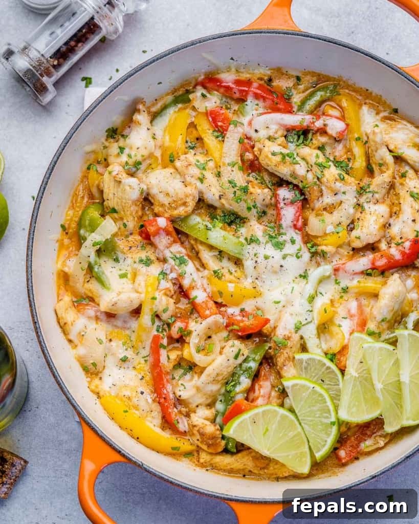 Dreamy Creamy Chicken Fajita Skillet 8 Close-up view of a creamy chicken fajita skillet garnished with lime wedges and fresh cilantro, highlighting the vibrant colors and rich texture.