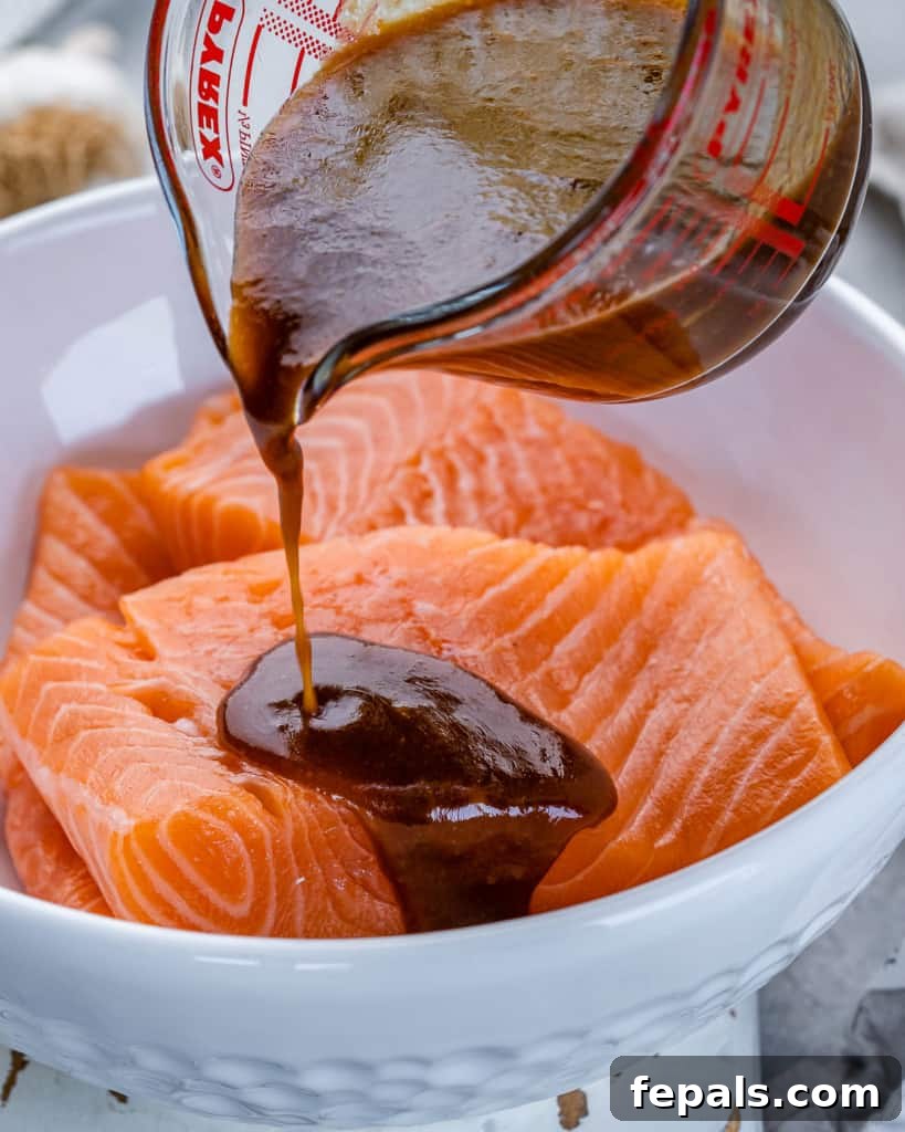 Umami Miso Salmon 5 miso glaze being poured over salmon filets, illustrating the coating process