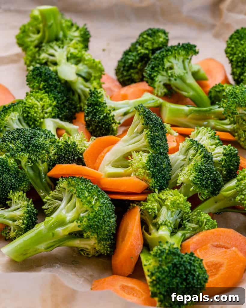 Umami Miso Salmon 6 freshly chopped broccoli florets and thinly sliced carrots on a baking tray, ready for roasting