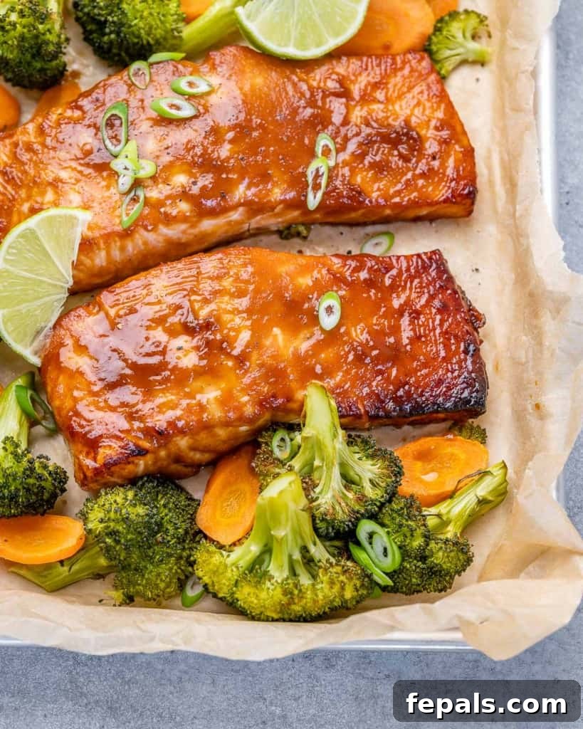 Umami Miso Salmon 9 side shot of several miso glazed salmon fillets on a sheet pan with roasted broccoli and carrots