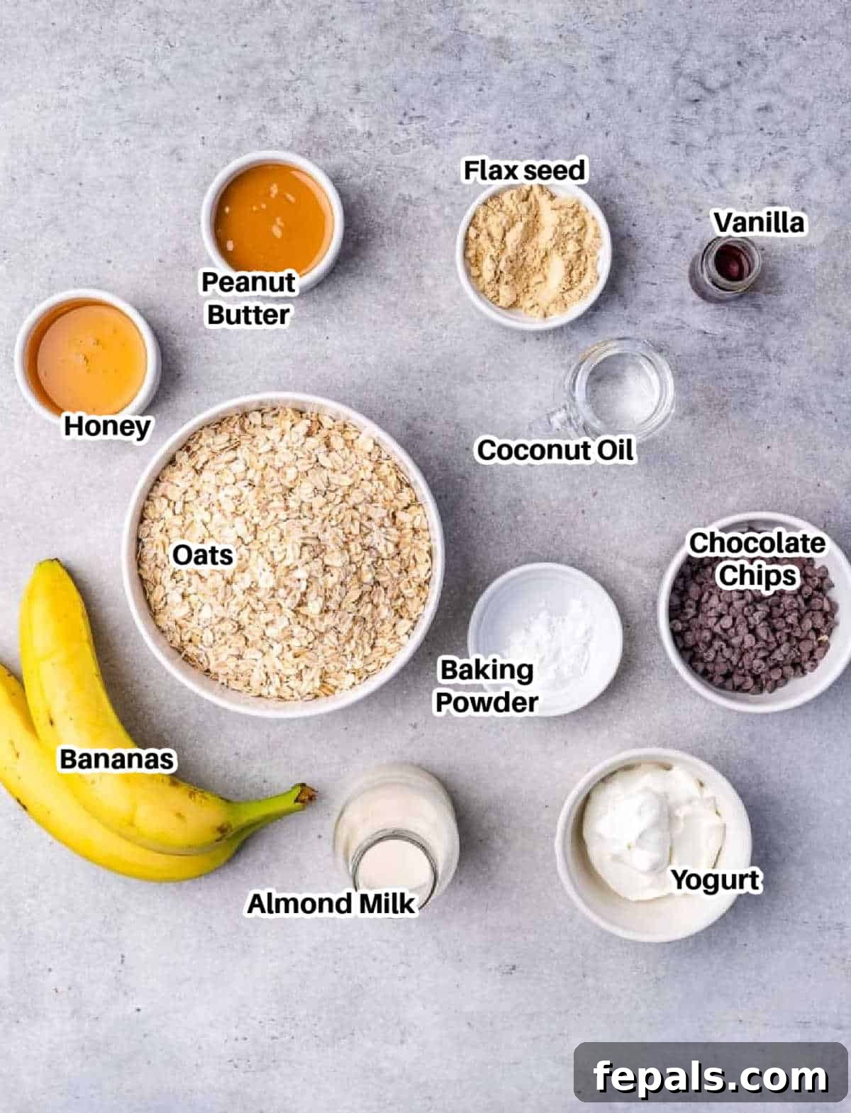 An array of ingredients laid out on a table, ready to be combined for chocolate chip oatmeal bars.