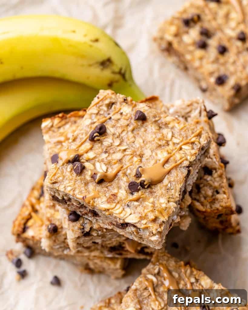 Top view of perfectly arranged stacks of chocolate chip oatmeal bars, with fresh bananas beside them, emphasizing their wholesome nature.