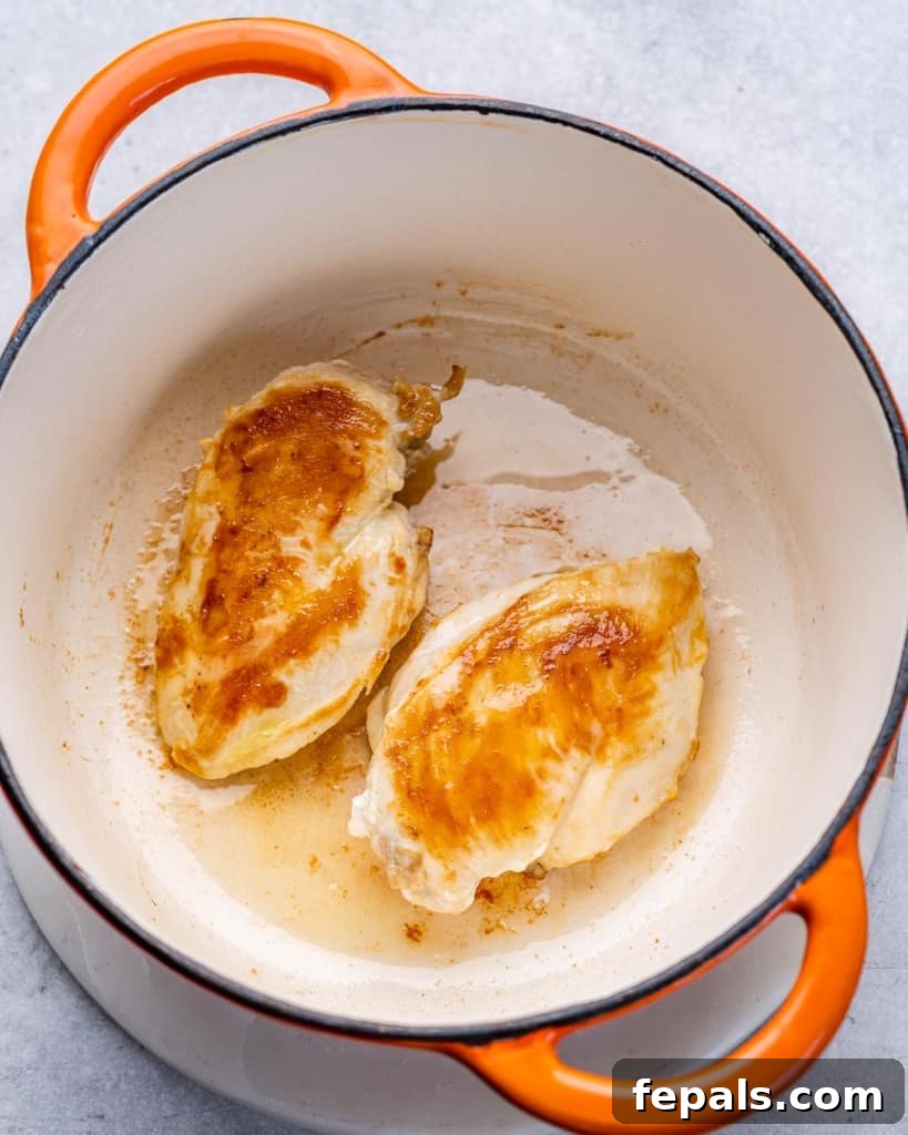 two chicken breasts cooked in a dutch oven pot