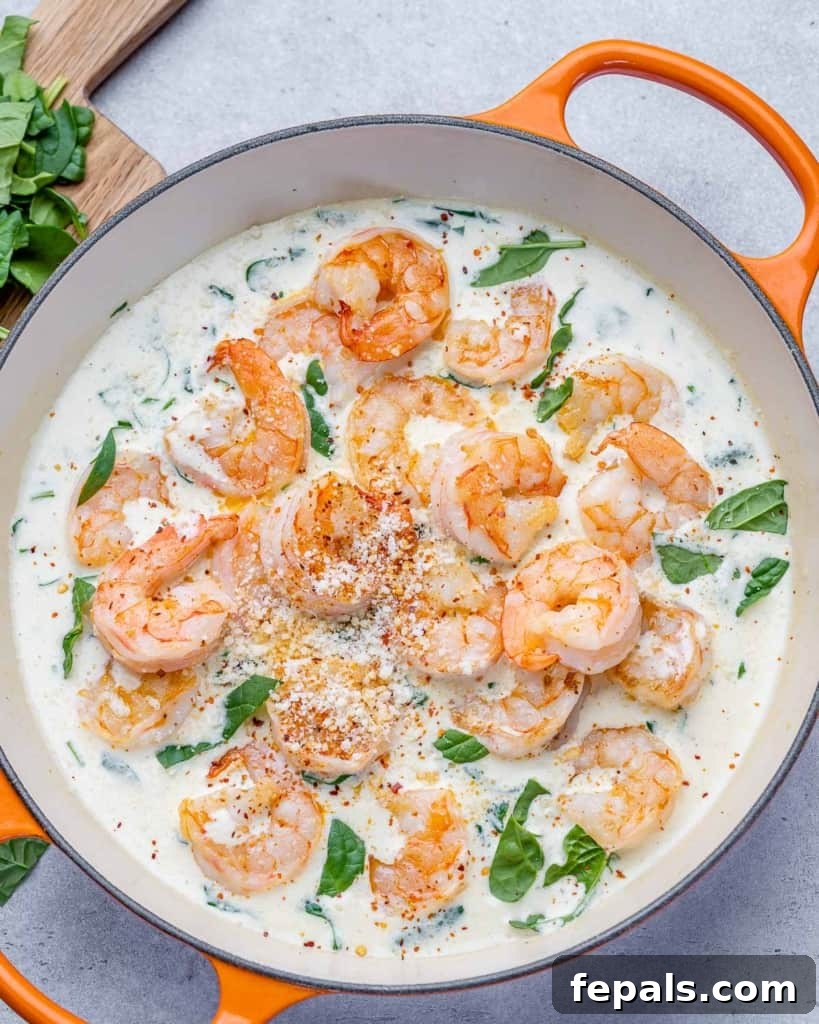 Top view of sauteed shrimp in a creamy garlic spinach sauce, serving suggestion.