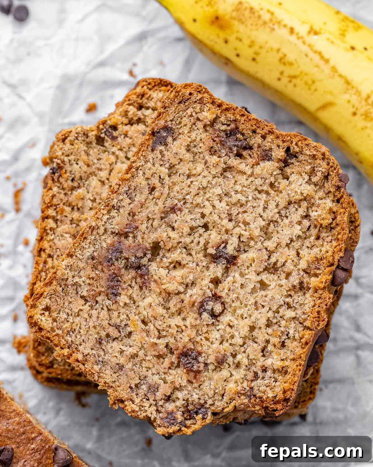 A close-up view of a perfectly baked slice of moist vegan banana bread, showing its delightful texture and golden-brown crust.