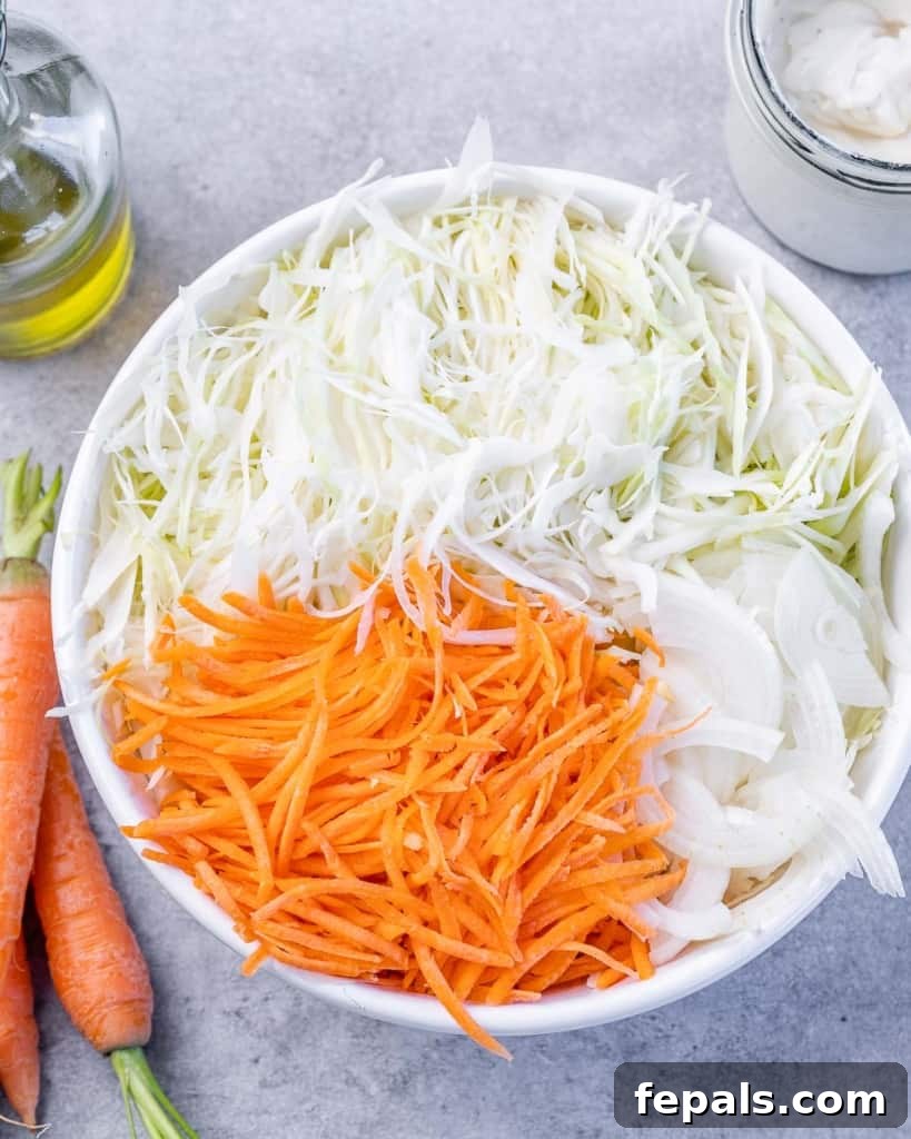 Wholesome Homemade Coleslaw 5 shredded carrots, shredded cabbage and sliced onions in a white bowl