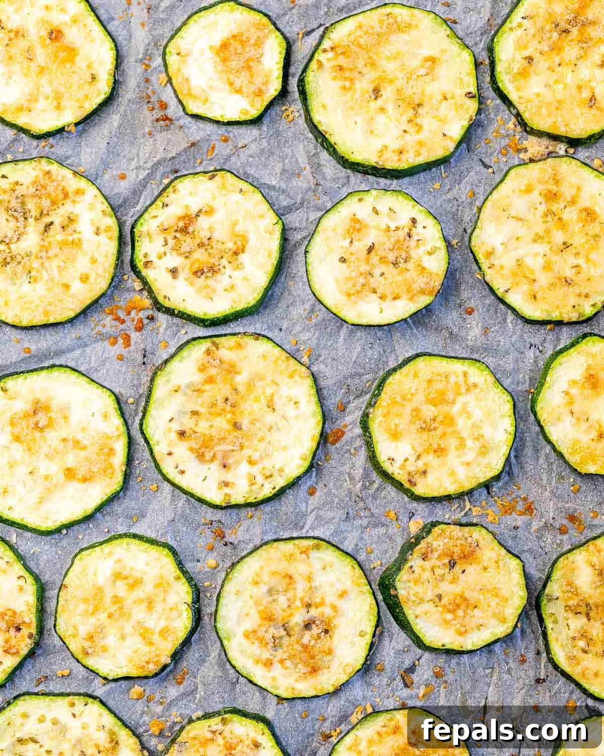 Oven-Baked Zucchini Chips baked zucchini chips on a sheet pan.