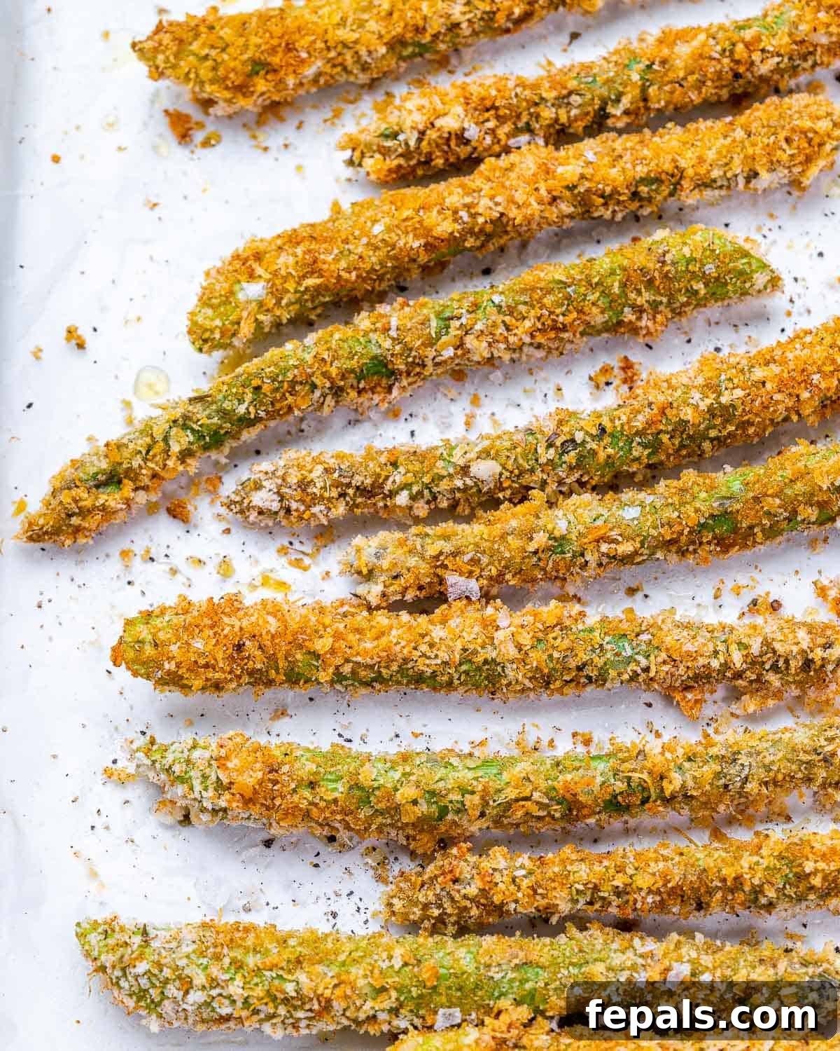 crispy asparagus on white baking sheet. 