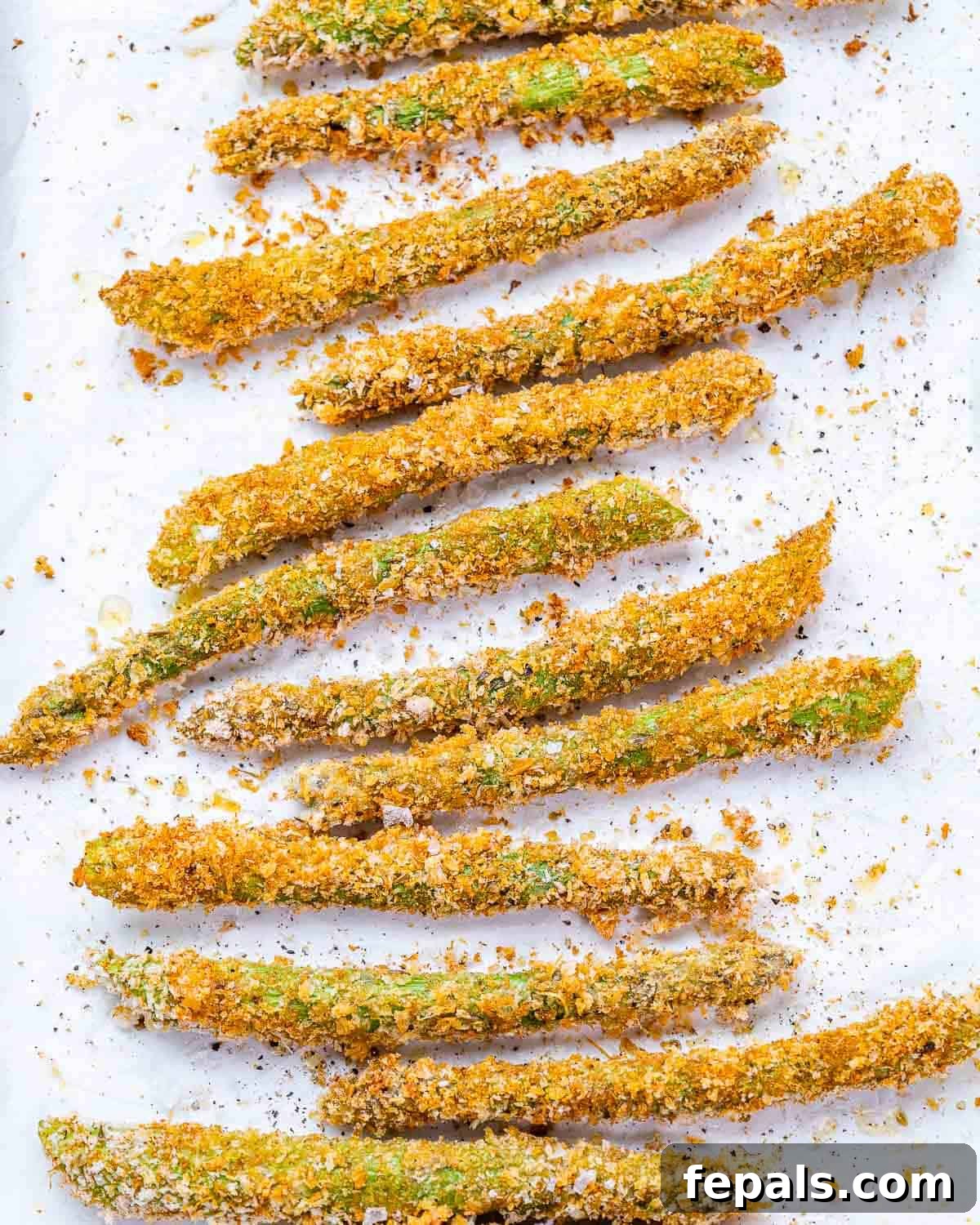 Oven baked asparagus on white pan. 