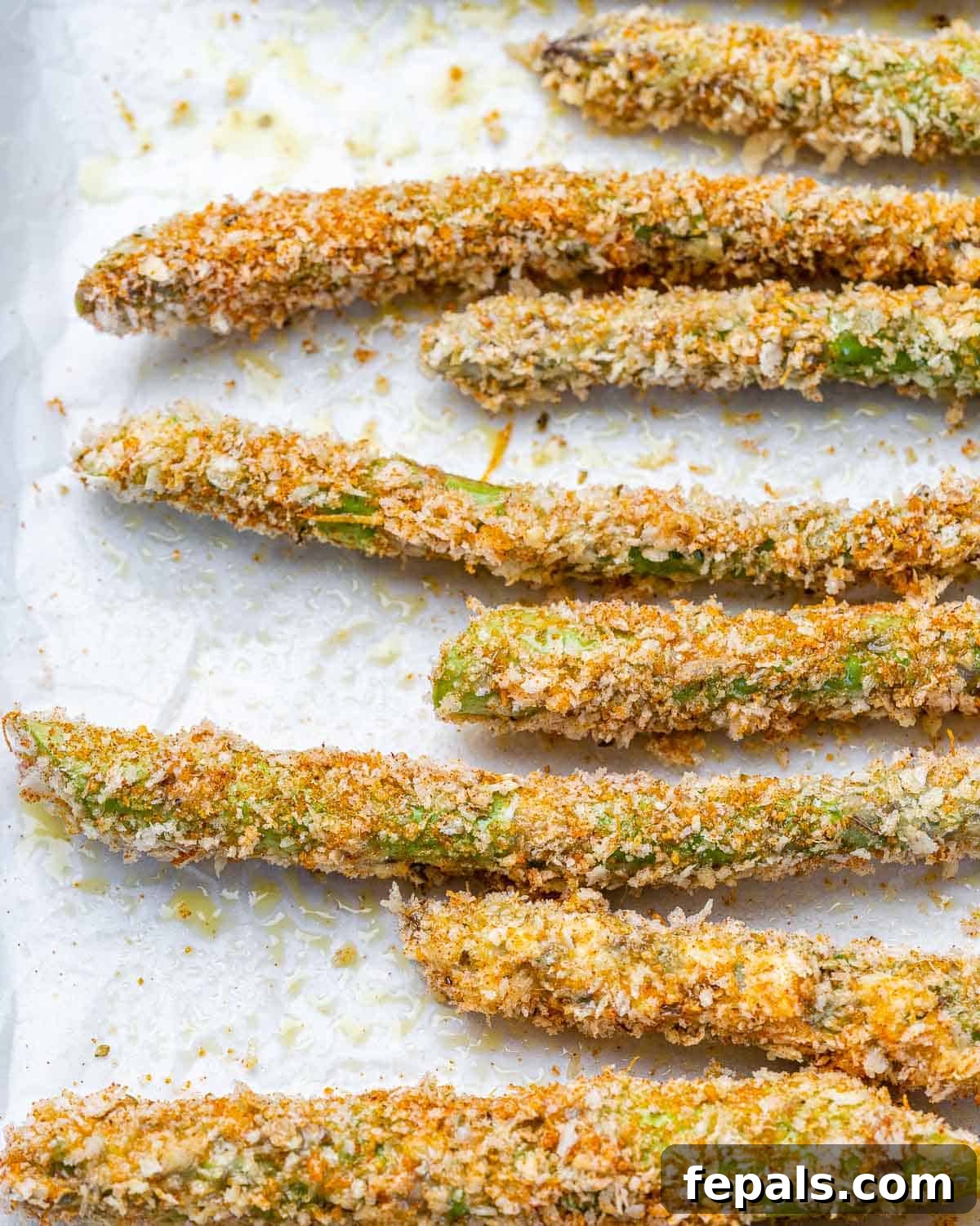 Coated asparagus on prepared baking sheet.