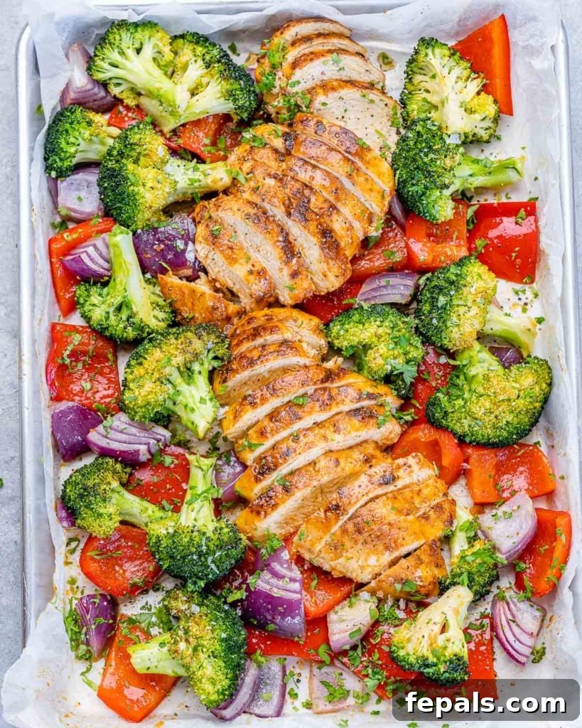 top view sliced baked chicken breast with veggies on a sheet pan