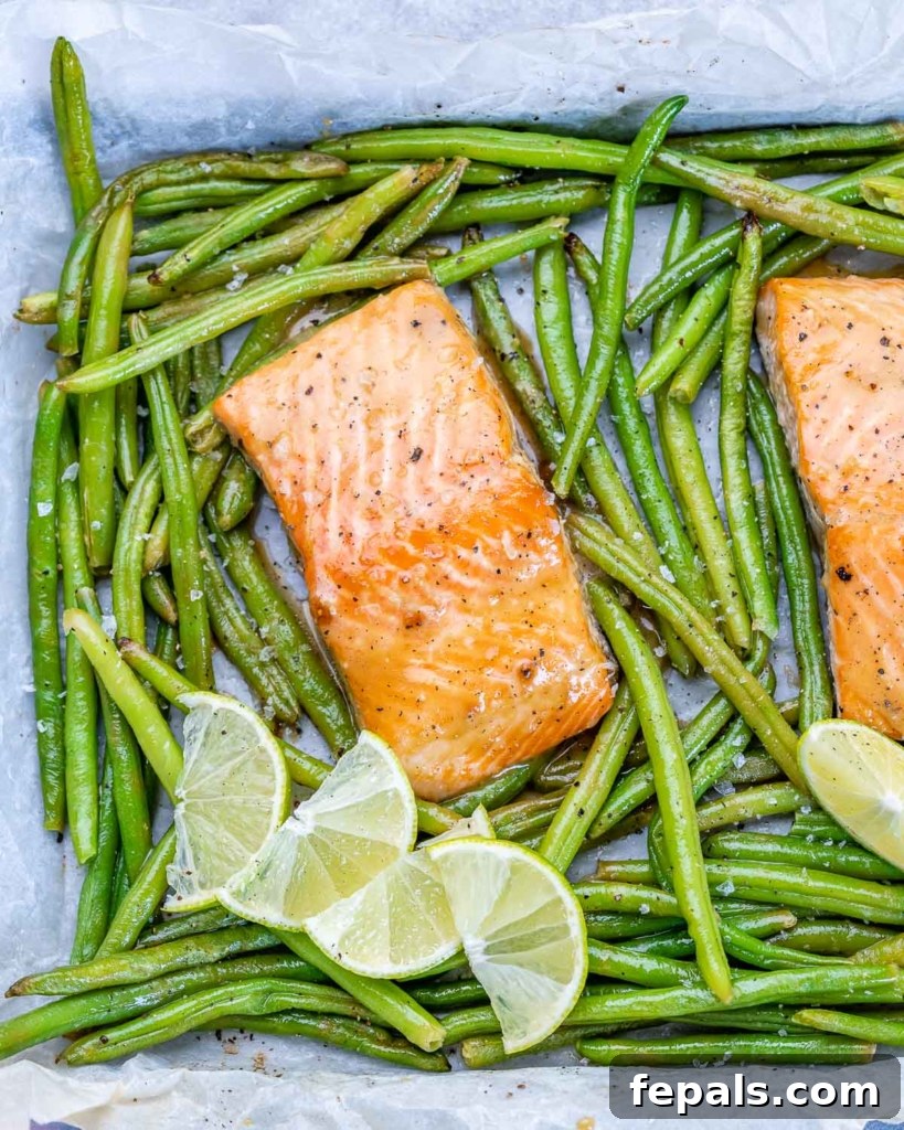 two salmon filets on sheet pan with green beans and lime