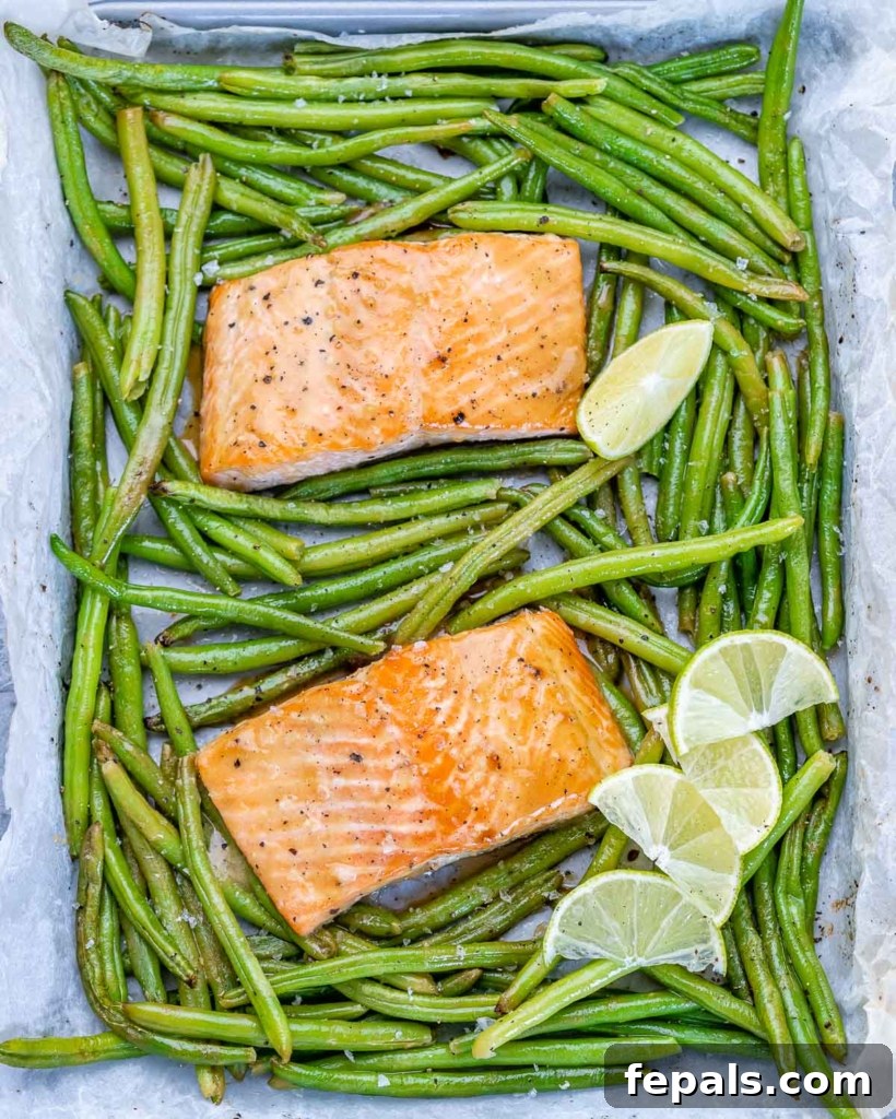 2 baked salmon filets on a pan surrounded with green beans