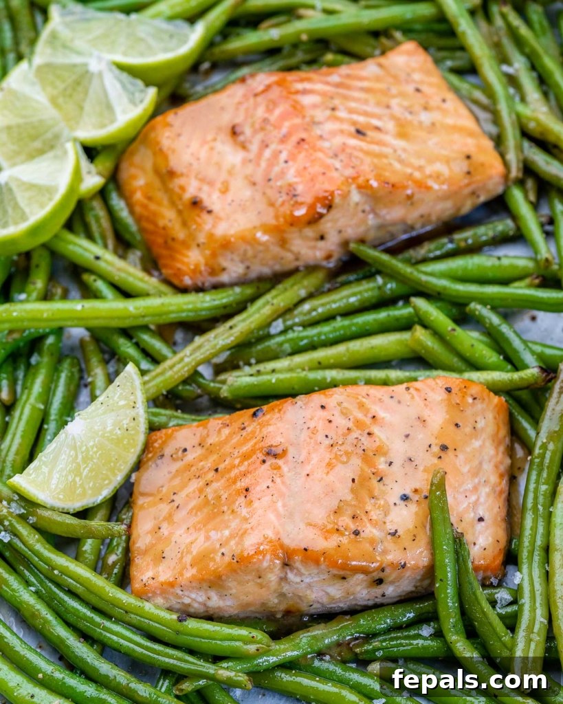 two salmon filets with green beans and lime wedges