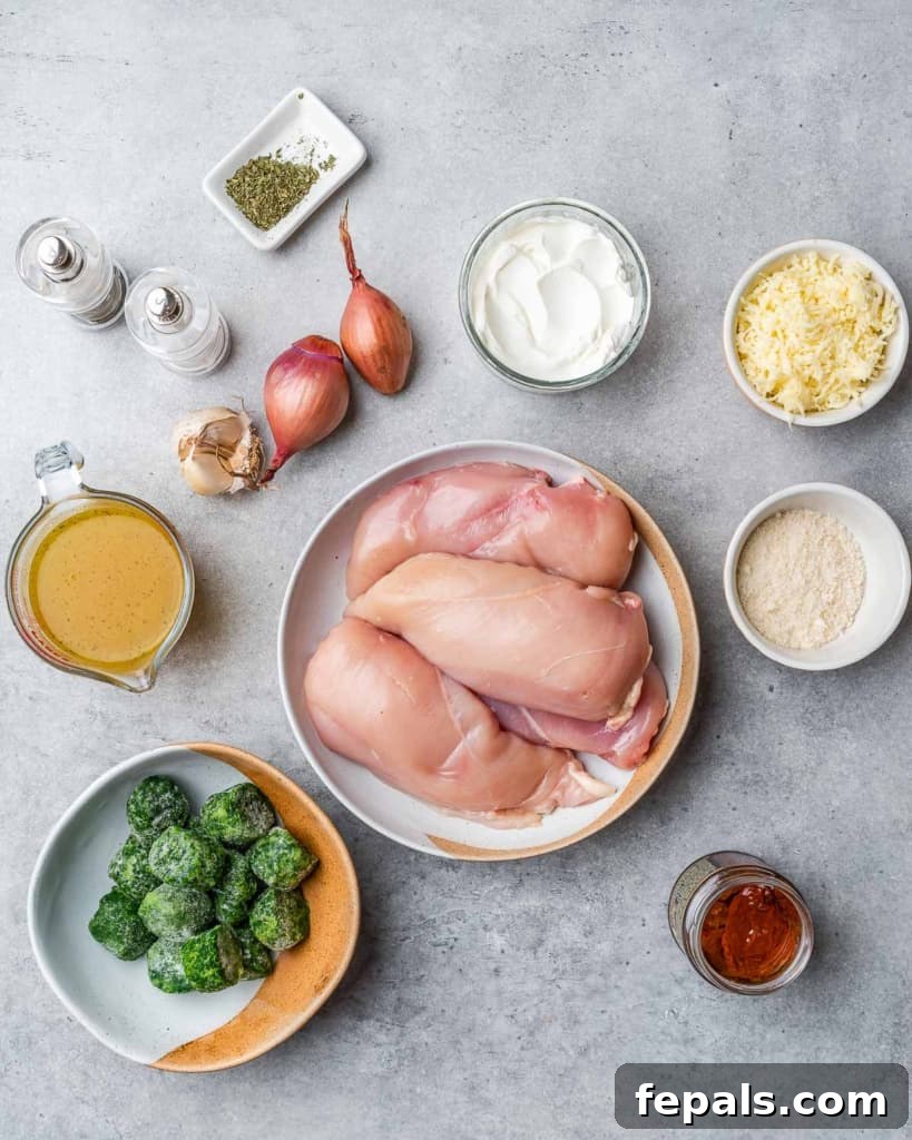 Tuscan Cheese-Stuffed Chicken 4 A vibrant selection of fresh ingredients laid out for preparing stuffed chicken breast, including spinach, sun-dried tomatoes, cheeses, and aromatics.