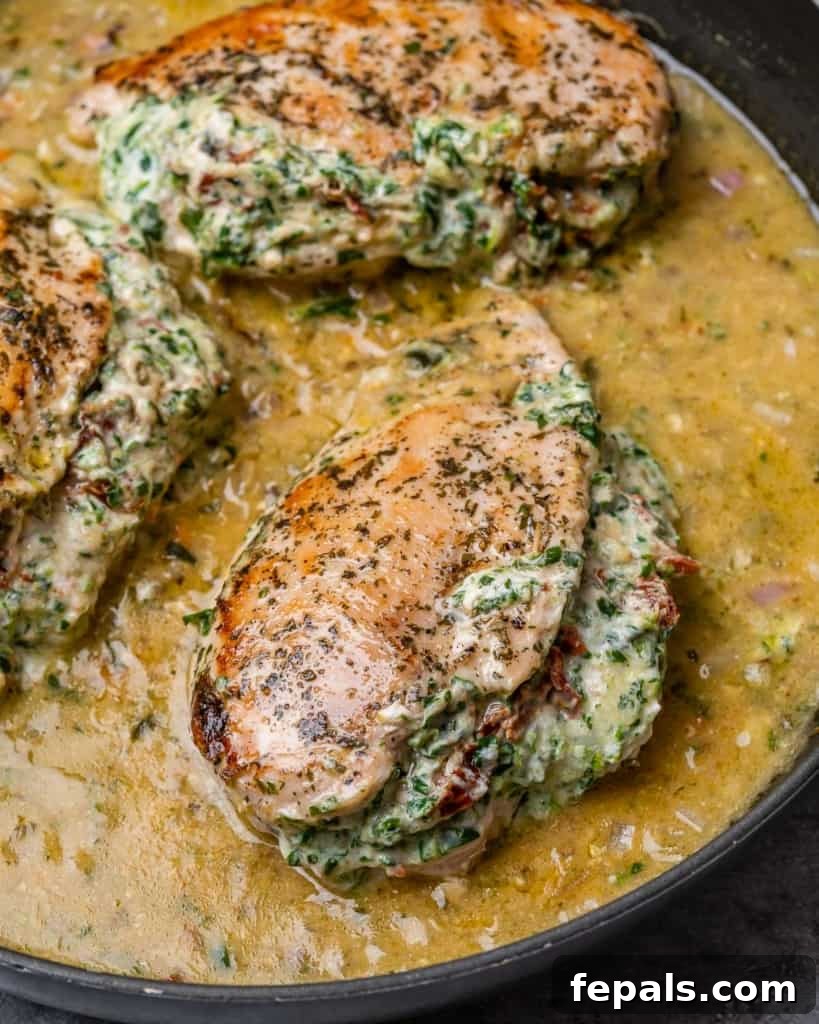 Tuscan Cheese-Stuffed Chicken 8 A beautifully presented Italian stuffed chicken breast generously coated in a creamy sauce, ready to be served from a black skillet.