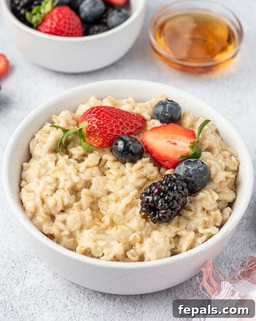 Effortless Instant Pot Oatmeal 9 side shot of oatmeal breakfast bowl topped with berries with side of maple syrup