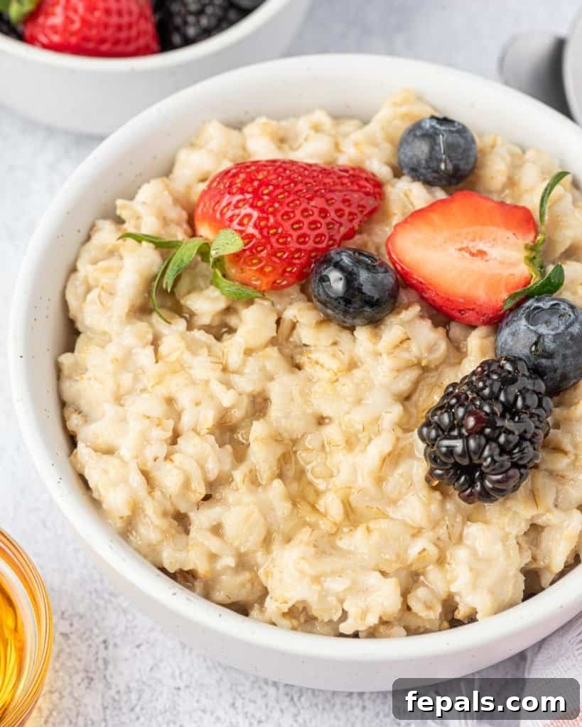 Effortless Instant Pot Oatmeal 10 side shot of oatmeal in a white bowl topped with fruits