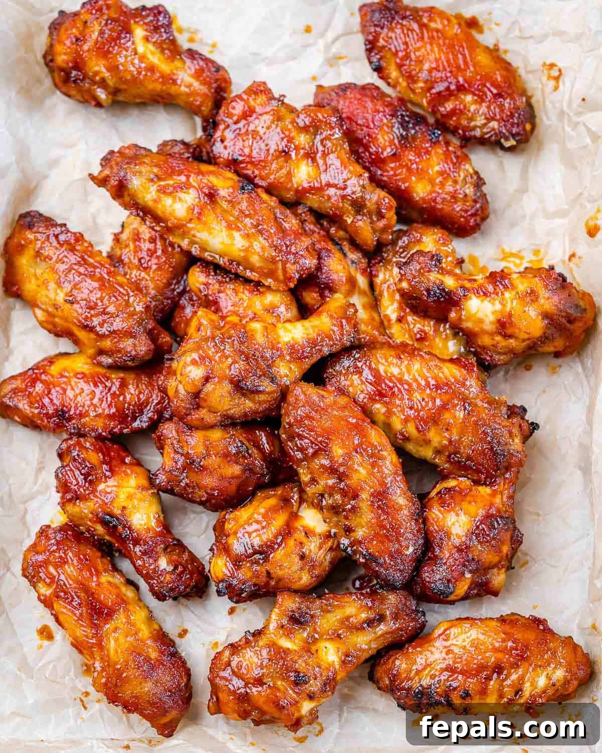 overhead shot of air fried Buffalo chicken wings on parchment paper.