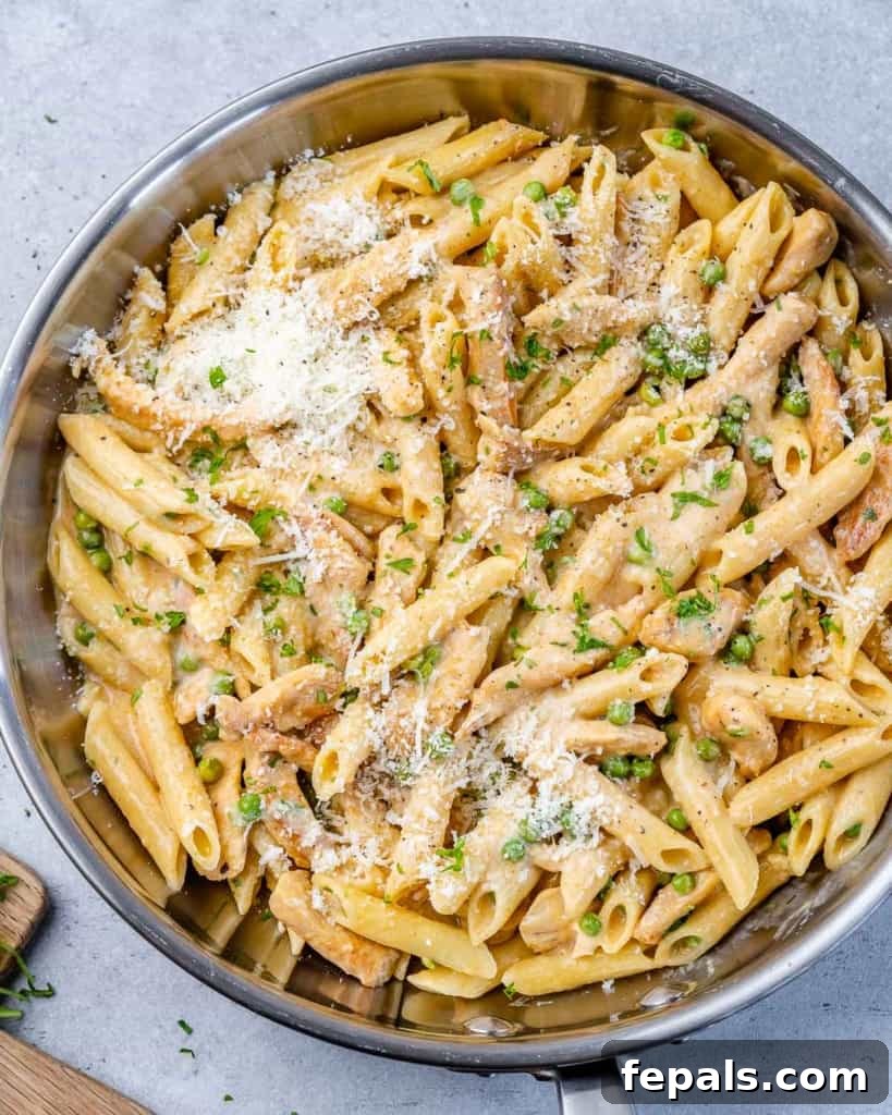 Lighter Chicken Carbonara 2 Top view of chicken pasta in a silver skillet, garnished with fresh herbs.