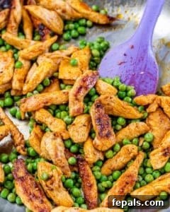 Lighter Chicken Carbonara 14 Chicken and peas sauteed in a pan with a purple spoon in the skillet.