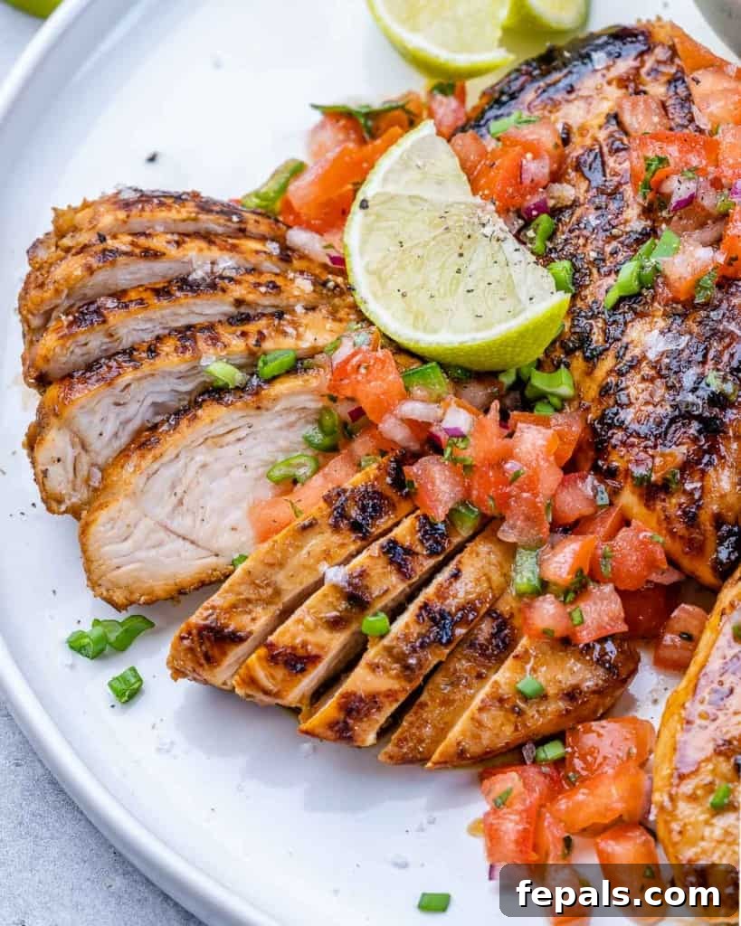 The Ultimate Jerk Chicken 3 Side shot of perfectly sliced grilled chicken breast on a white plate, showing the tender, juicy interior.