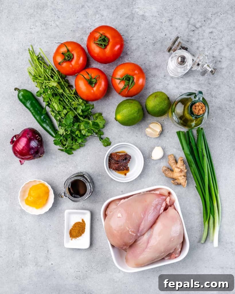 The Ultimate Jerk Chicken 4 A collection of fresh ingredients for the Jerk Chicken marinade and salsa, artfully arranged on a grey background.