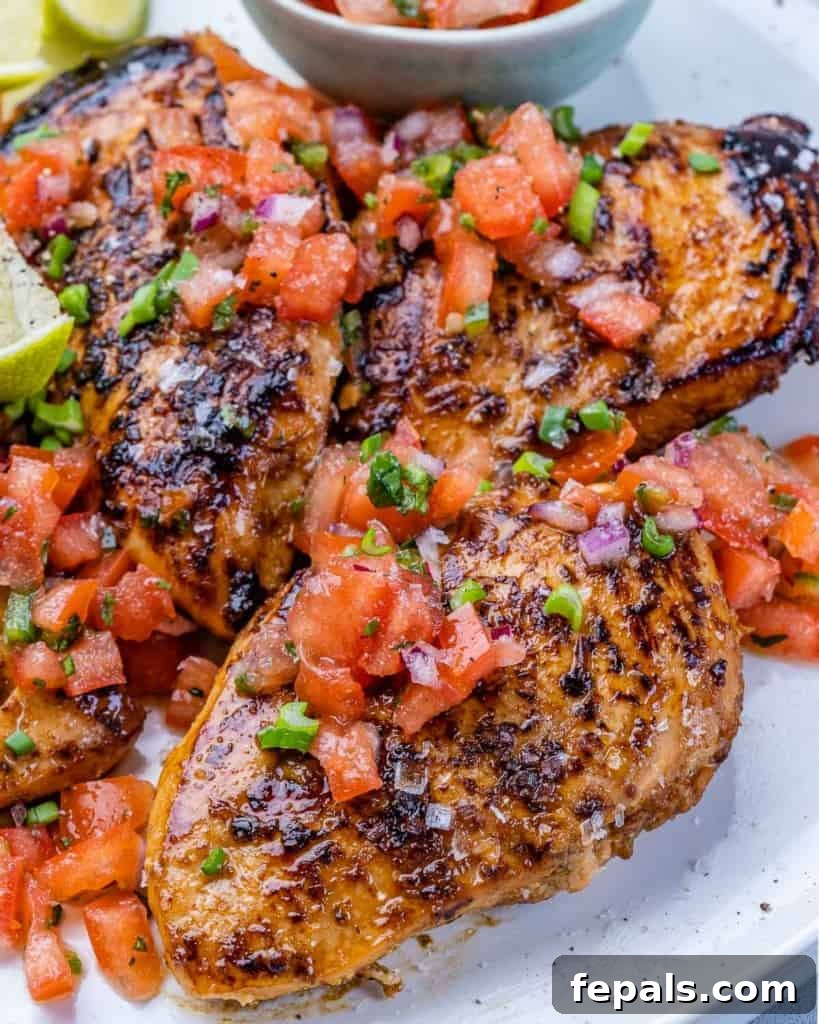 The Ultimate Jerk Chicken 6 Close-up image of a succulent grilled chicken breast, beautifully topped with a vibrant tomato salsa.