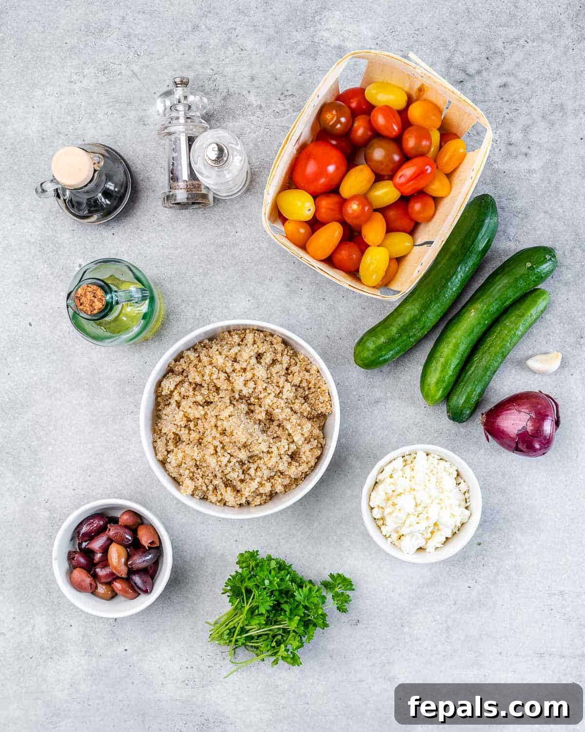 Vibrant Mediterranean Quinoa Salad 4 A beautiful arrangement of fresh ingredients for Mediterranean salad on a pristine white table.