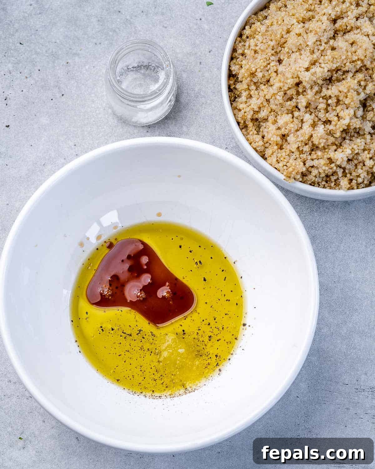 Vibrant Mediterranean Quinoa Salad 5 Ingredients for the Mediterranean salad dressing, vigorously whisked in a circular white bowl.