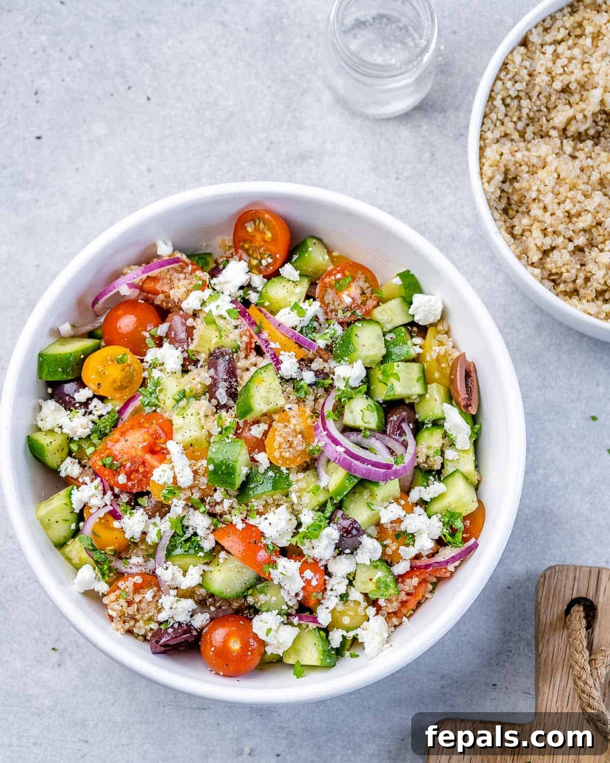Vibrant Mediterranean Quinoa Salad 7 The Mediterranean quinoa salad beautifully tossed and ready to serve in a circular white bowl.