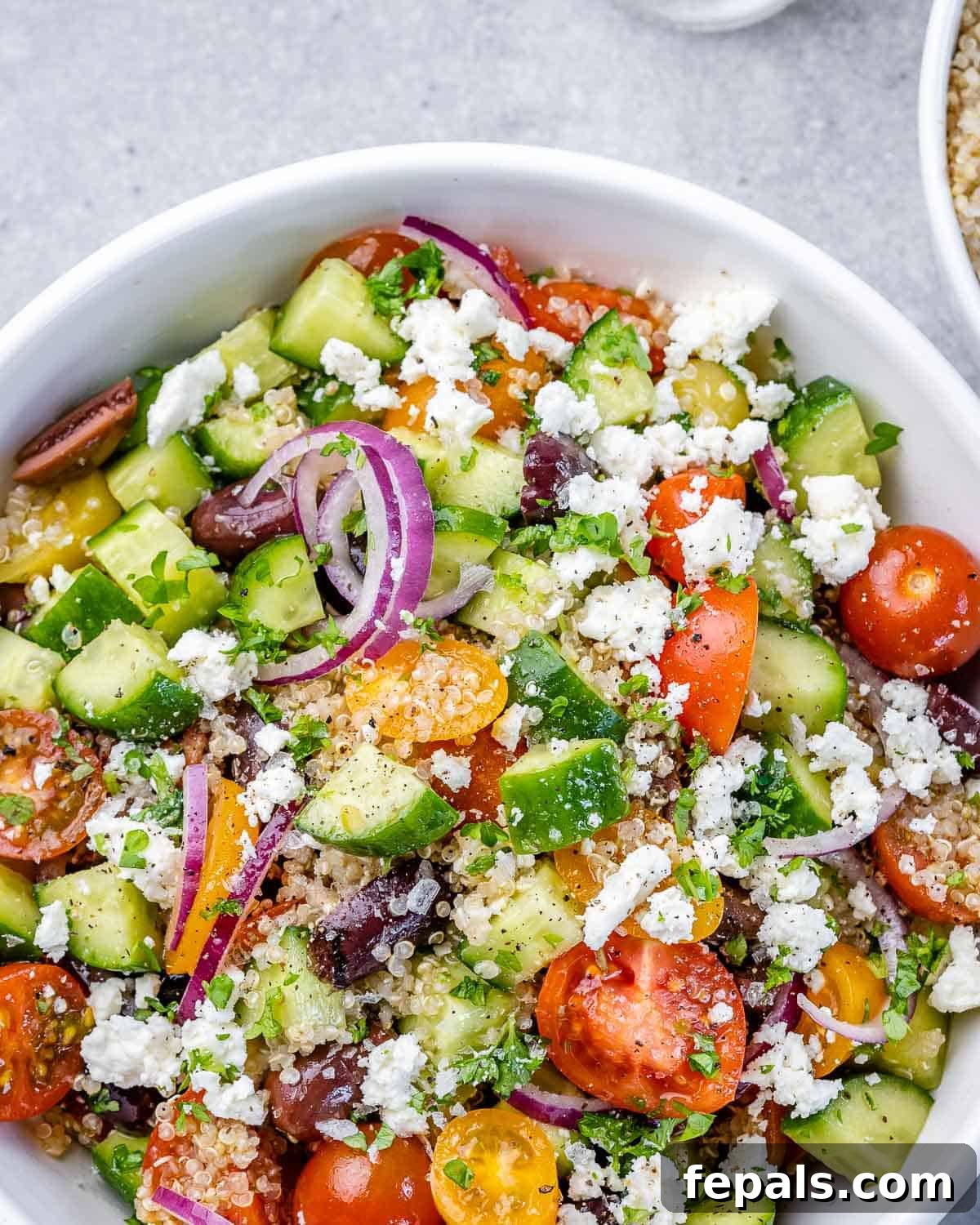 Vibrant Mediterranean Quinoa Salad 9 Close-up of a perfectly portioned Mediterranean quinoa salad in a circular white serving bowl.