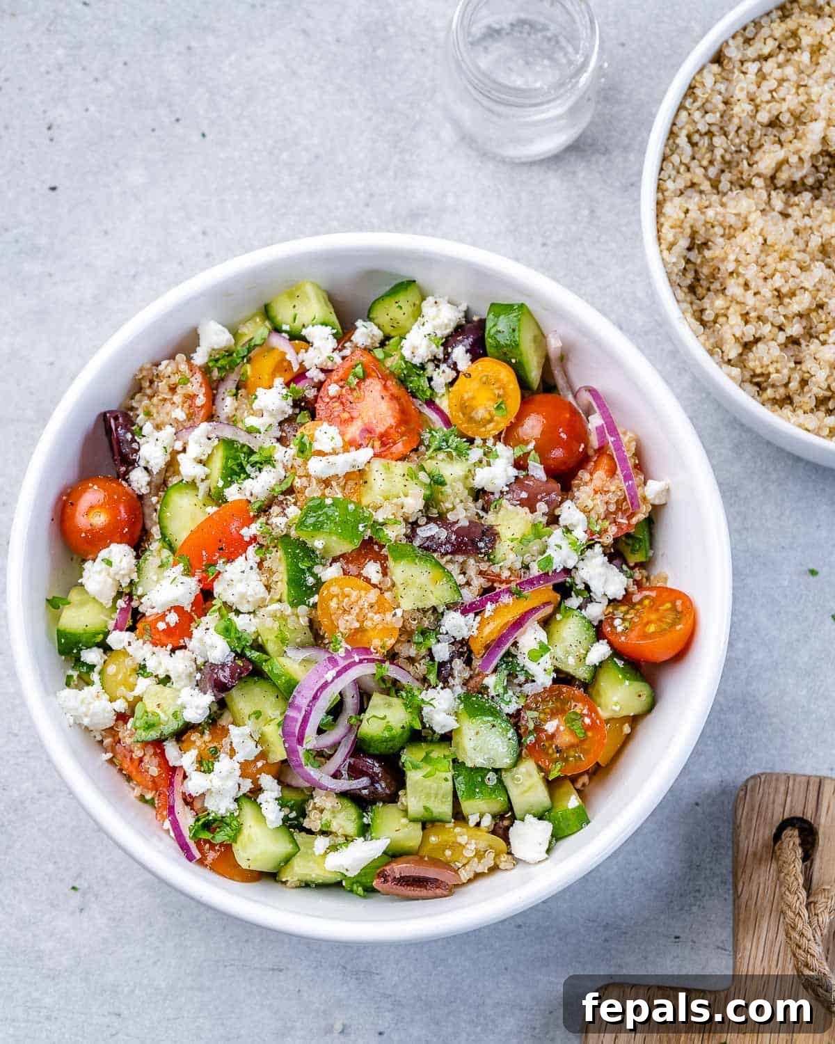 Vibrant Mediterranean Quinoa Salad 10 Overhead shot of Mediterranean quinoa salad in a circular white serving bowl, showcasing its vibrant colors.