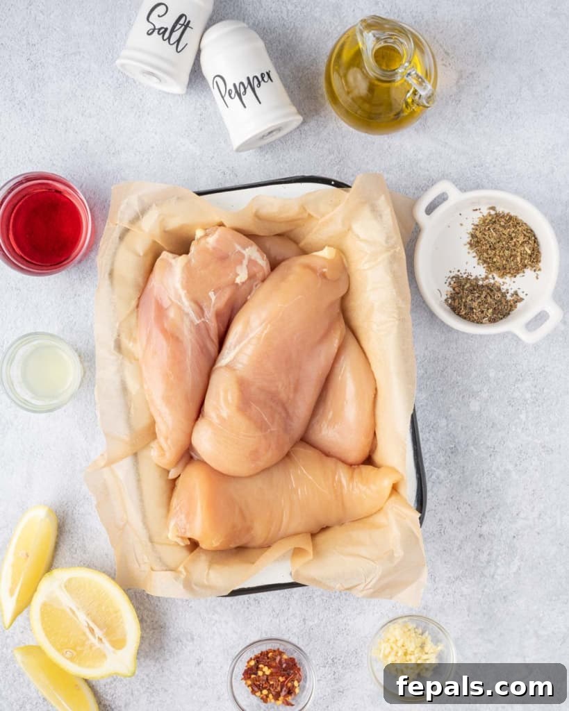 Juicy Italian Grilled Chicken Breasts 4 Various ingredients laid out for making Italian grilled chicken breasts, including olive oil, herbs, lemons, and chicken.