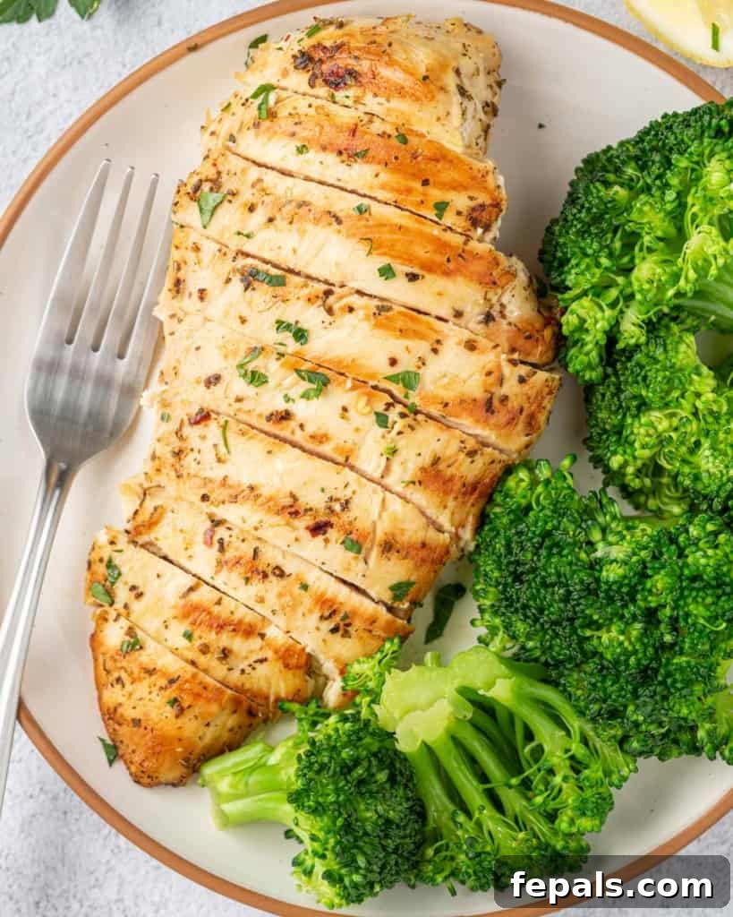 Juicy Italian Grilled Chicken Breasts 10 Close-up of a perfectly cooked, sliced Italian chicken breast with a vibrant side of steamed broccoli, ready for a healthy meal.